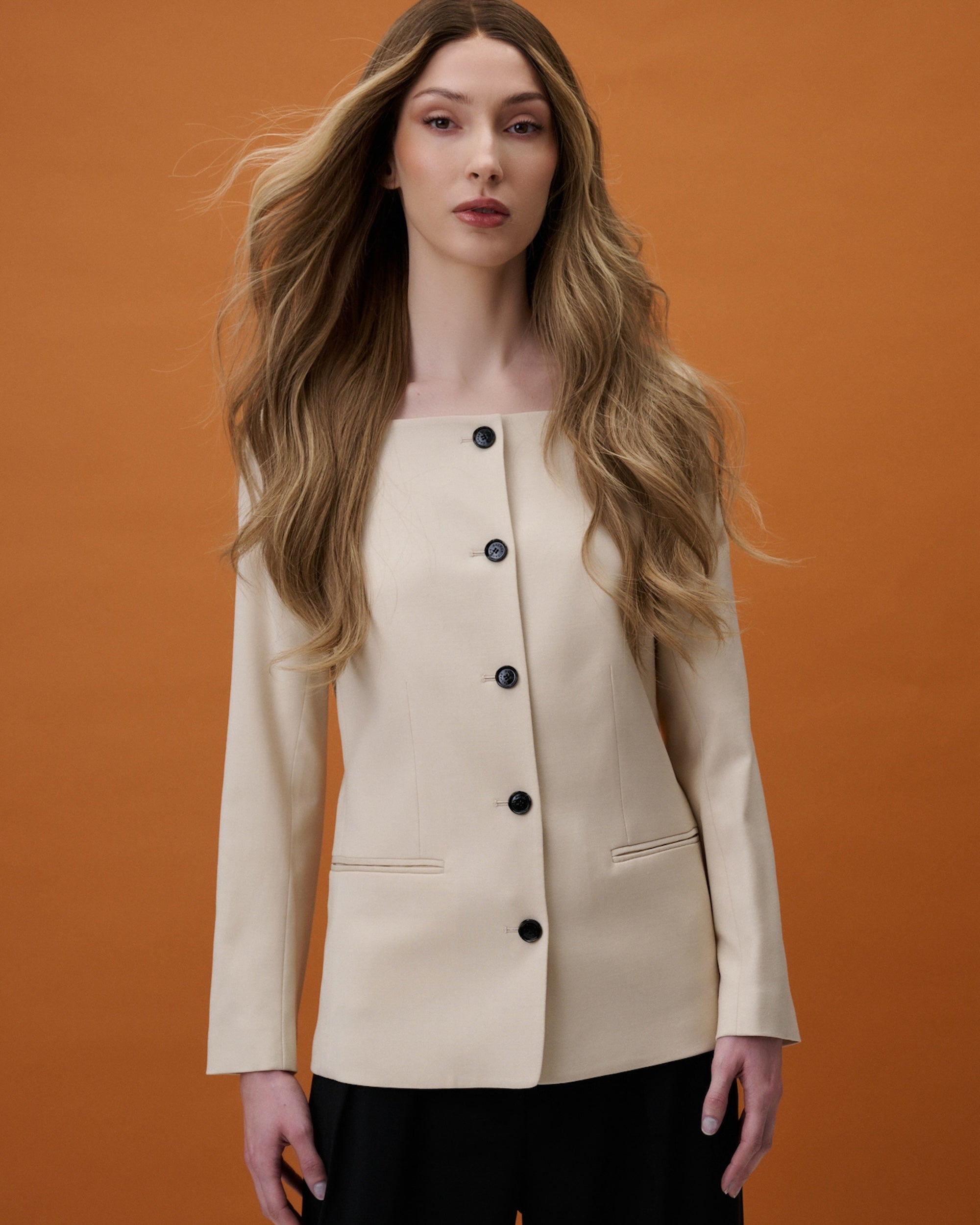 Noble Nightshade Wig 50 cm in blended dark blonde and light beige blonde tones, softly layered with front highlights for a modern touch, shown on model in studio setting