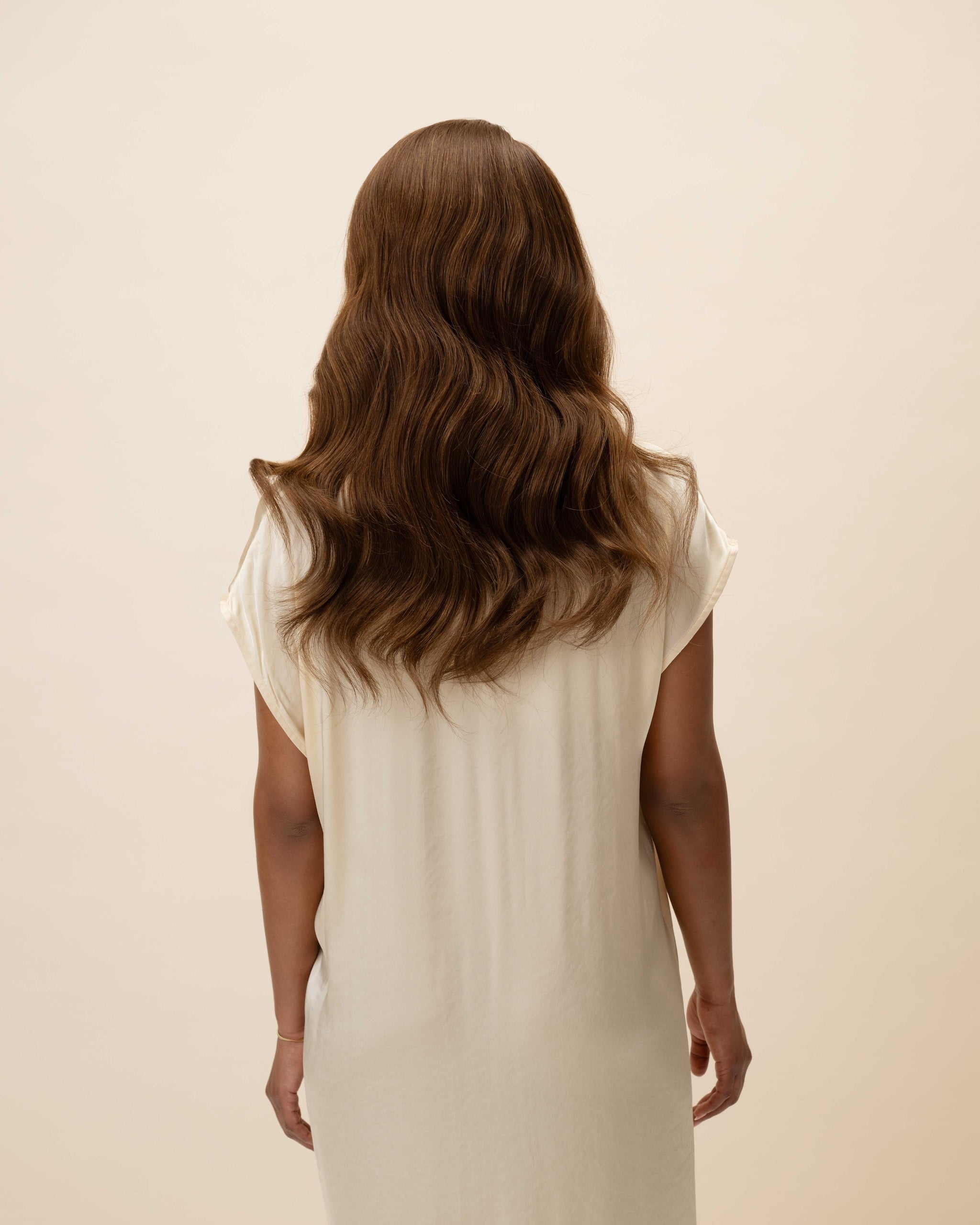 Daisy Wig 40 cm Remy human hair wig in dark brown with subtle light brown highlights, softly layered and shown from the back on model.