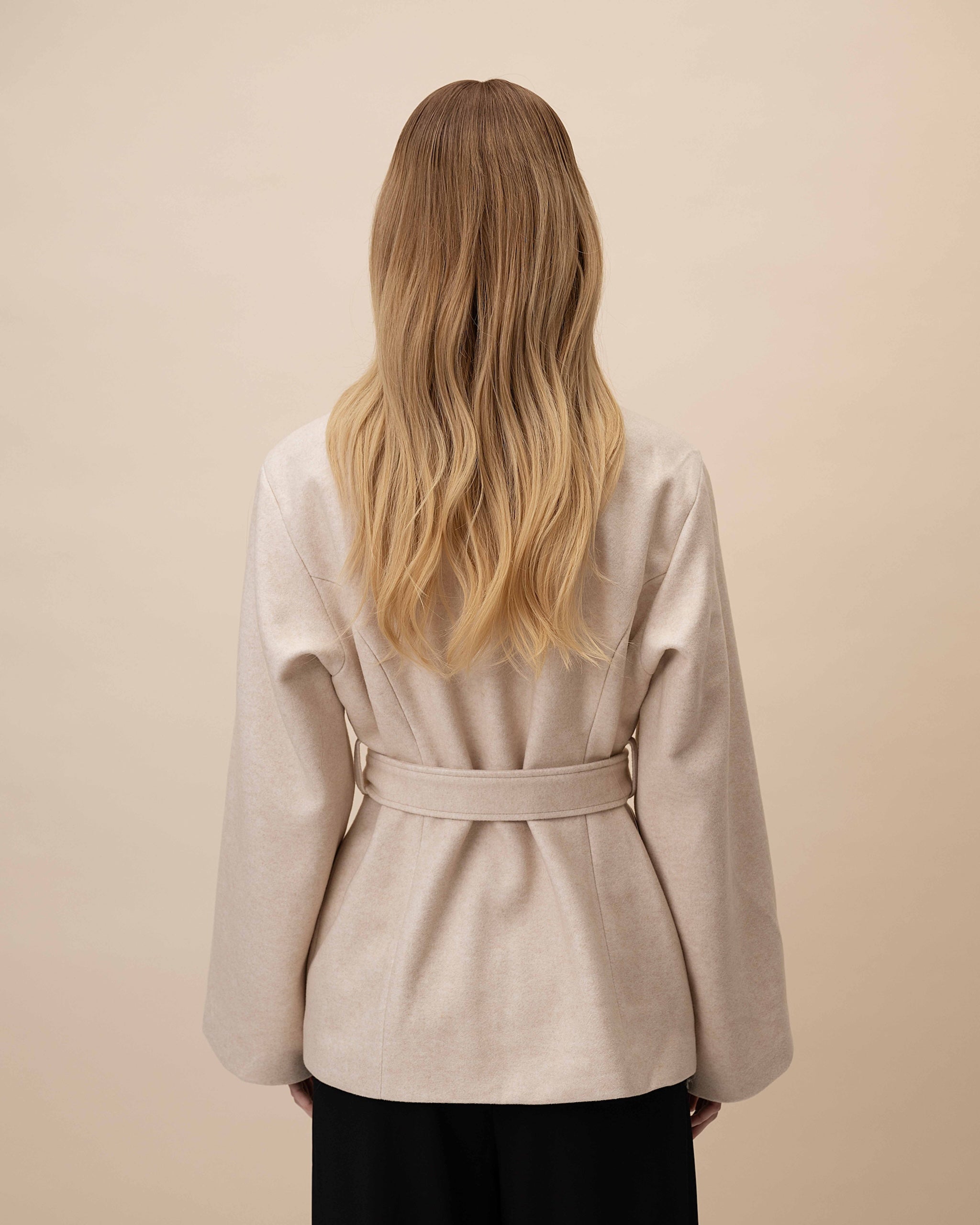 Statice Wig 40 cm medium blonde human hair with softly layered lengths and natural darker root, shown from the back on model to highlight the smooth cut