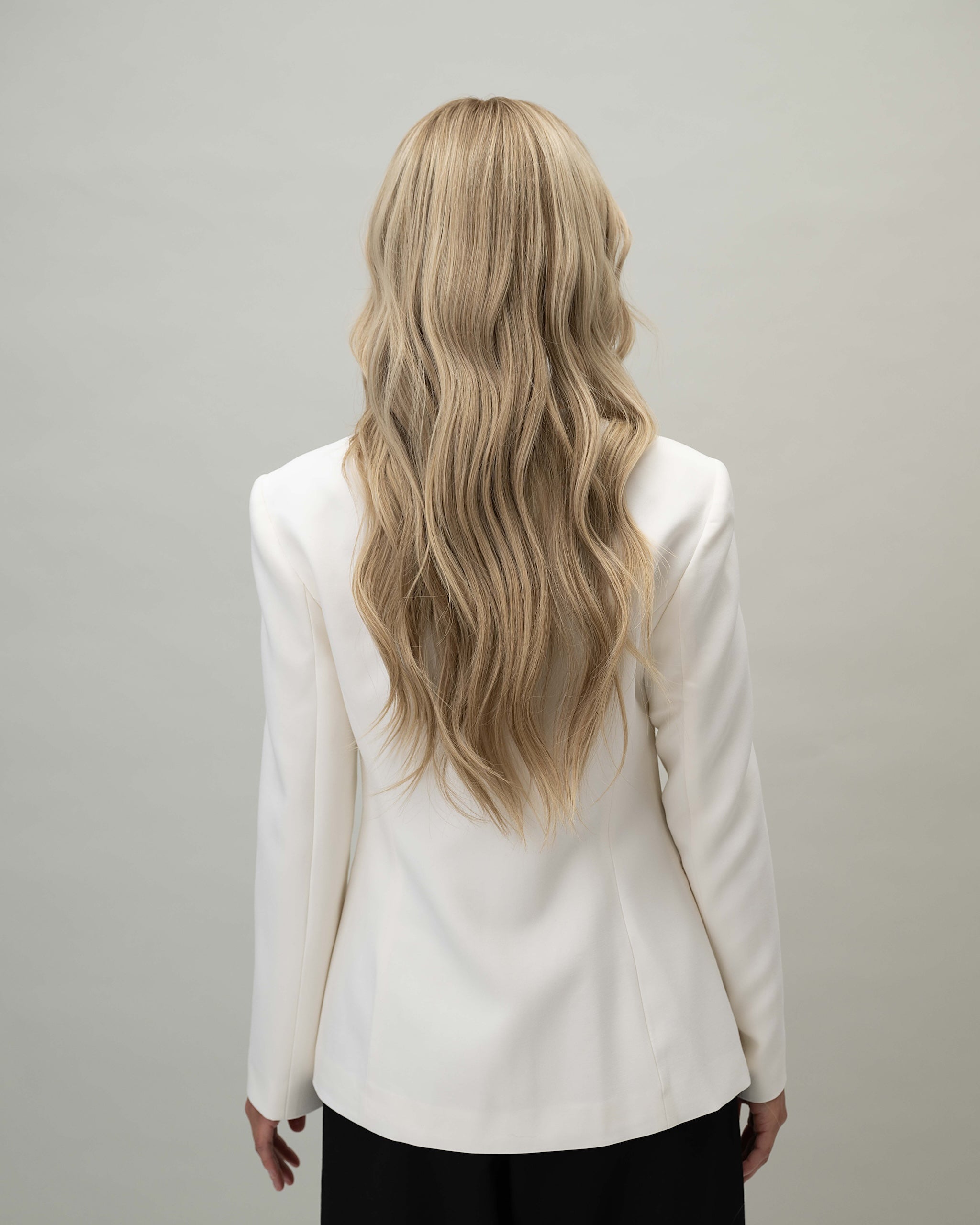 Scarlet Wig 50 cm Remy human hair wig with darker blonde roots blending into natural blonde lengths with lowlights, shown from back.