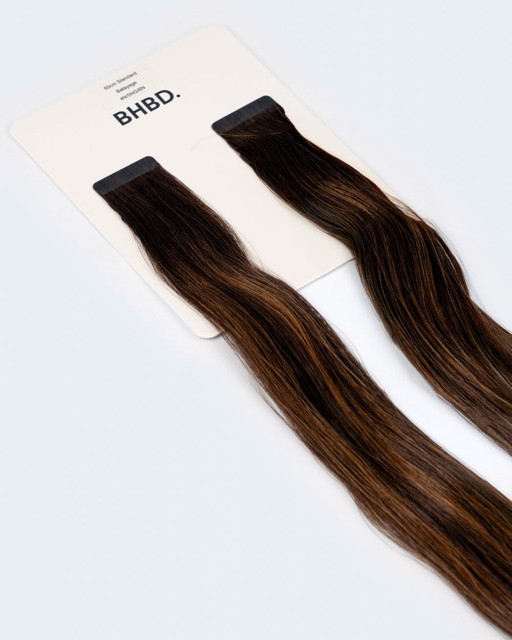 BHBD Tape Extensions 4N/5NG/6N – pre-taped Remy human hair extensions in deep brown and neutral blonde tones; seamless, soft and tangle-free; comes in 35cm, 50cm, and 60cm. 100% Remy hair, gentle extensions.