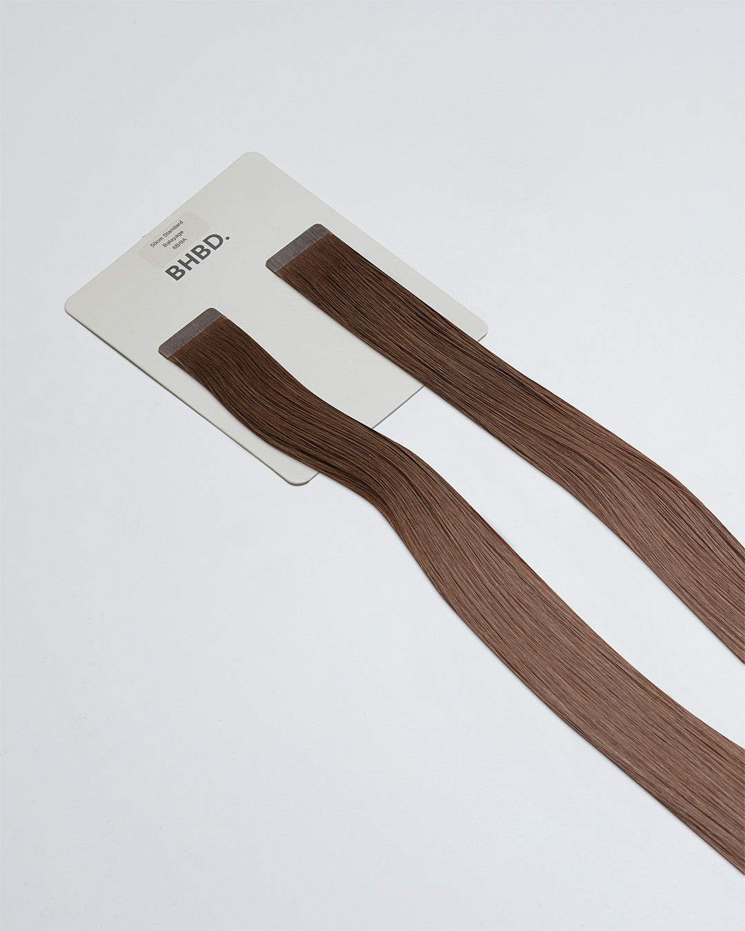 Tape Extensions 6B/9A – pre-taped Remy human hair extensions in medium brown and light ash blonde blend; seamless, soft and tangle-free; comes in 35cm, 50cm, and 60cm. 100% Remy hair, gentle extensions.