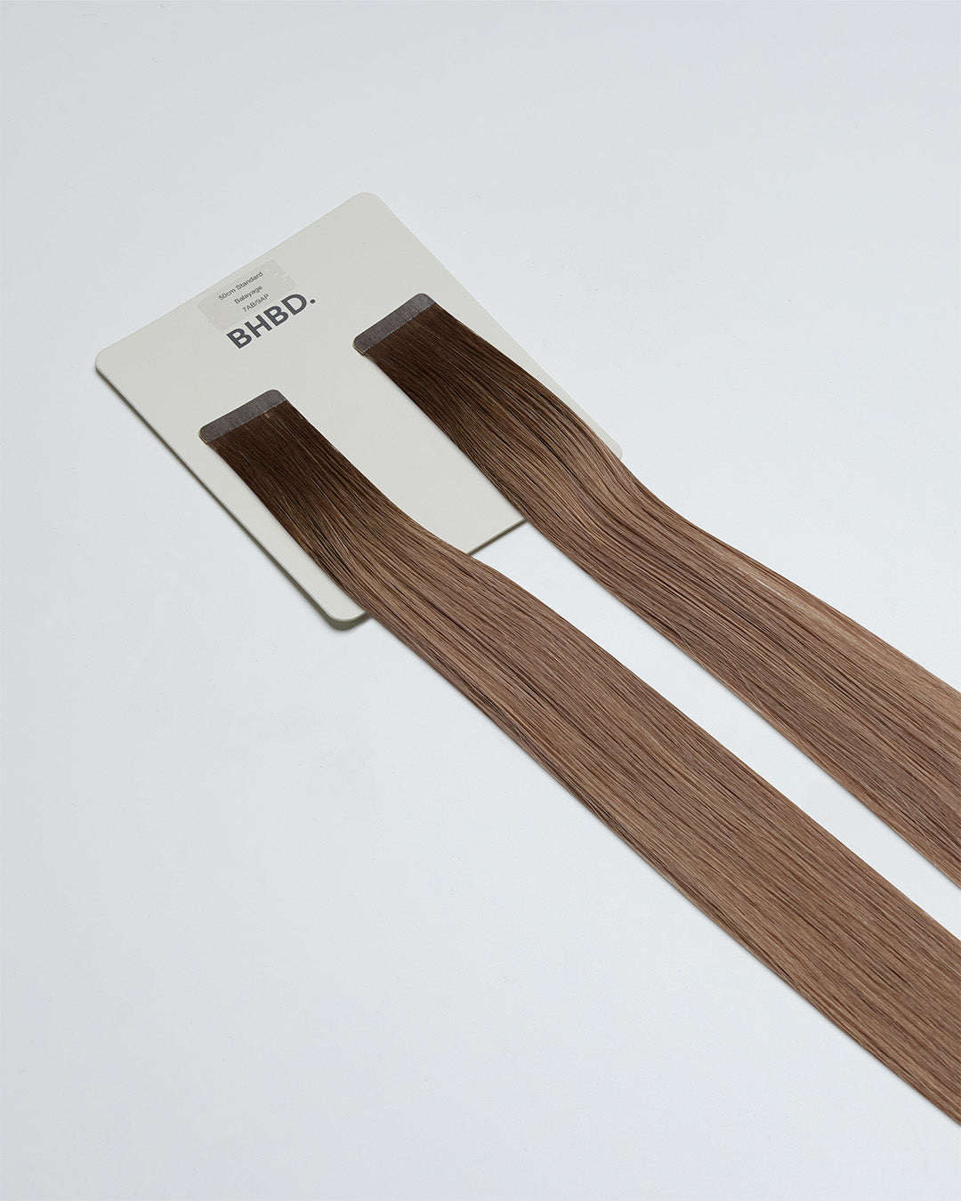 Tape Extensions 7AB/9AP – pre-taped Remy human hair extensions in ash brown blended with light ash blonde; seamless, soft and tangle-free; comes in 35cm, 50cm, and 60cm. 100% Remy hair, gentle extensions.