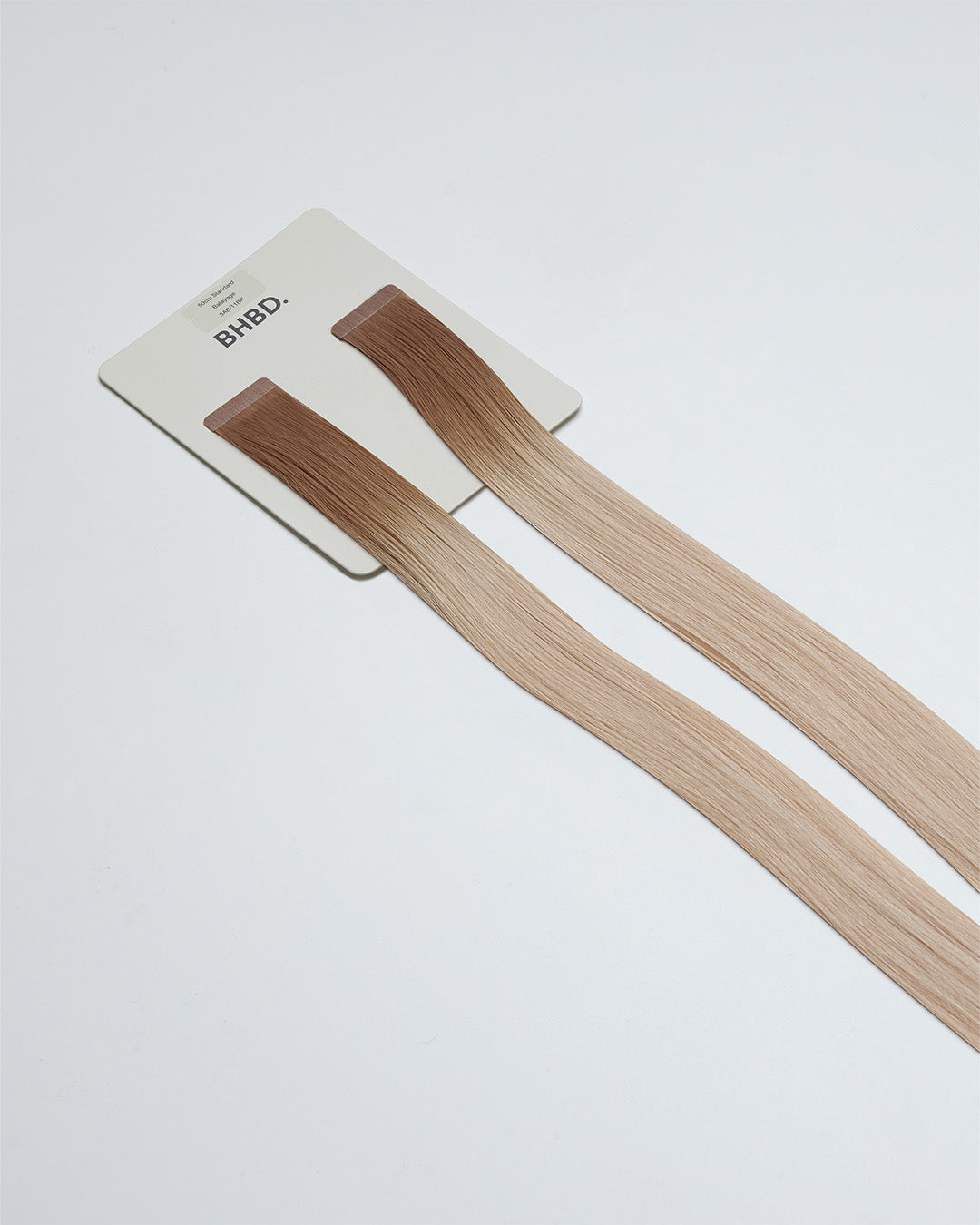 Tape Extensions 8AB/11BP – pre-taped Remy human hair extensions in medium ash blonde and pearl blonde tones; seamless, soft and tangle-free; comes in 35cm, 50cm, and 60cm. 100% Remy hair, gentle extensions.