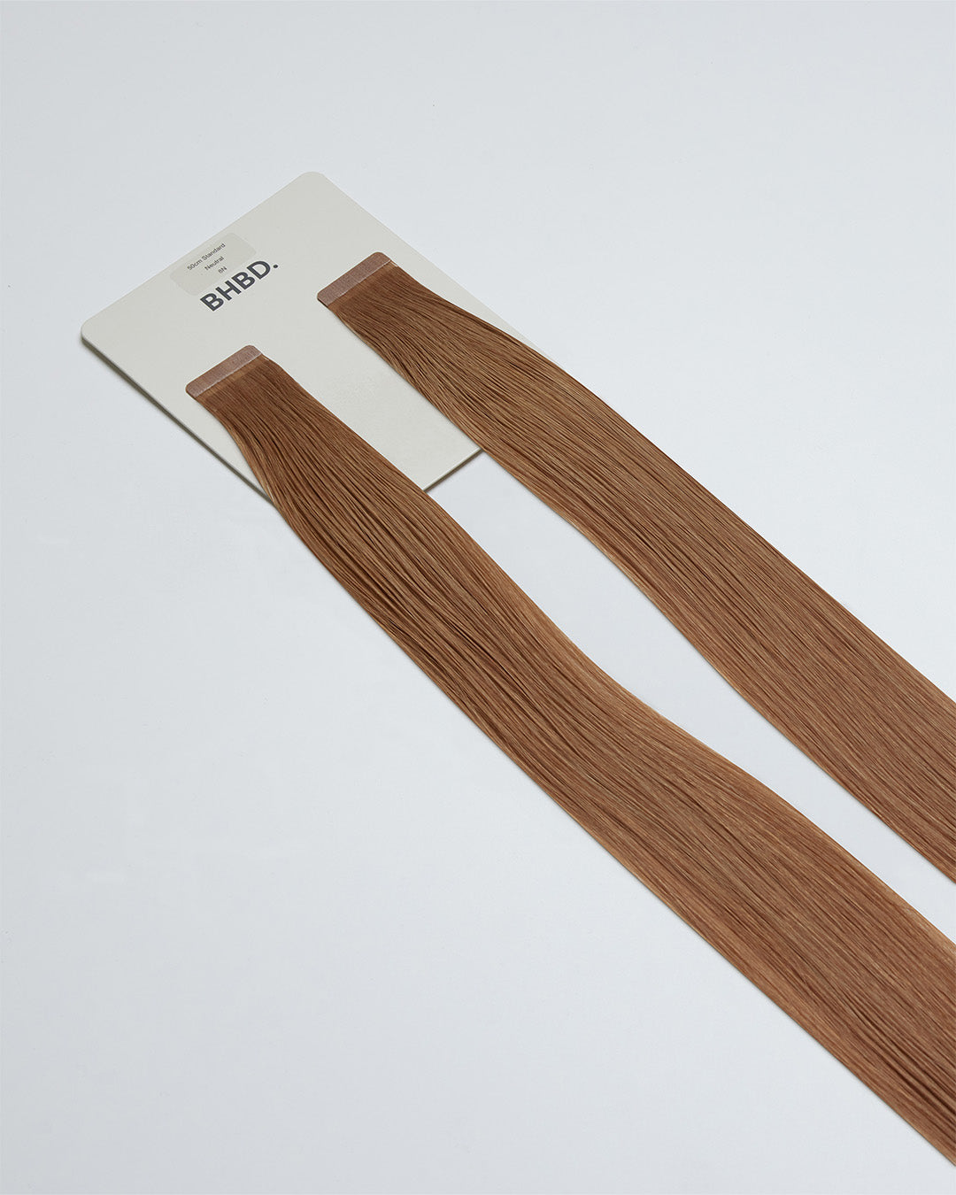 Tape Extensions 8N – pre-taped Remy human hair extensions in natural medium blonde shade; seamless, soft and tangle-free; comes in 35cm, 50cm, and 60cm. 100% Remy hair, gentle extensions.