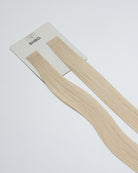 Tape Extensions 12N – pre-taped Remy human hair extensions in light natural blonde shade; seamless, soft and tangle-free; comes in 35cm, 50cm, and 60cm. 100% Remy hair, gentle extensions.