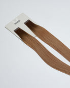 Tape Extensions 4N/8N – pre-taped Remy human hair extensions in dark brown blended with medium natural blonde; seamless, soft and tangle-free; comes in 35cm, 50cm, and 60cm. 100% Remy hair, gentle extensions.