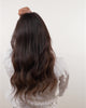 Woman with brown hair removing a BHBD hairband showing how the hair looks from the back with BHBD hairband hair extensions and without.