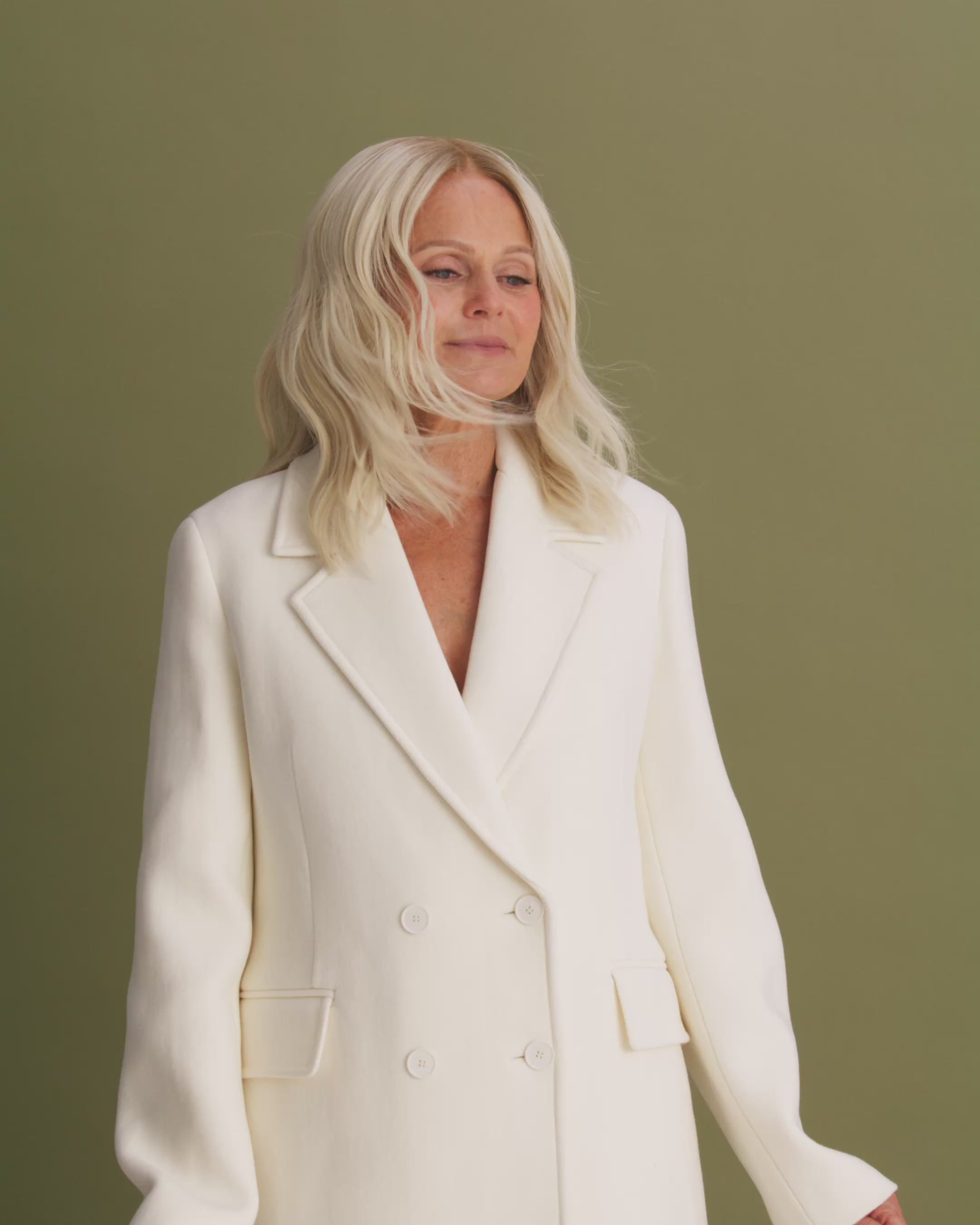 Video of Fiorella Wig 35 cm platinum ash blonde HD lace human hair wig with dark blonde root, showing natural shine and realistic scalp on model.